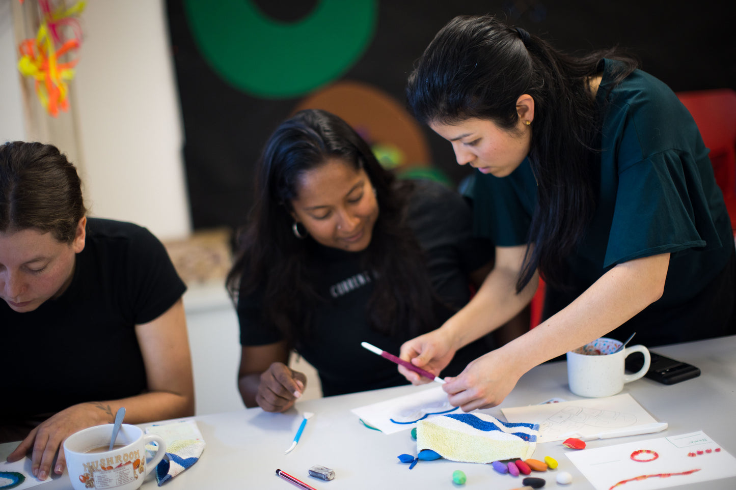 Clay Artist Emy Oikawa is guiding a participant at the Mindful Clay Art Workshop, helping her create the perfect texture for her first framed clay art piece. The participant is fully engaged and eager to learn, bringing her creative vision to life.