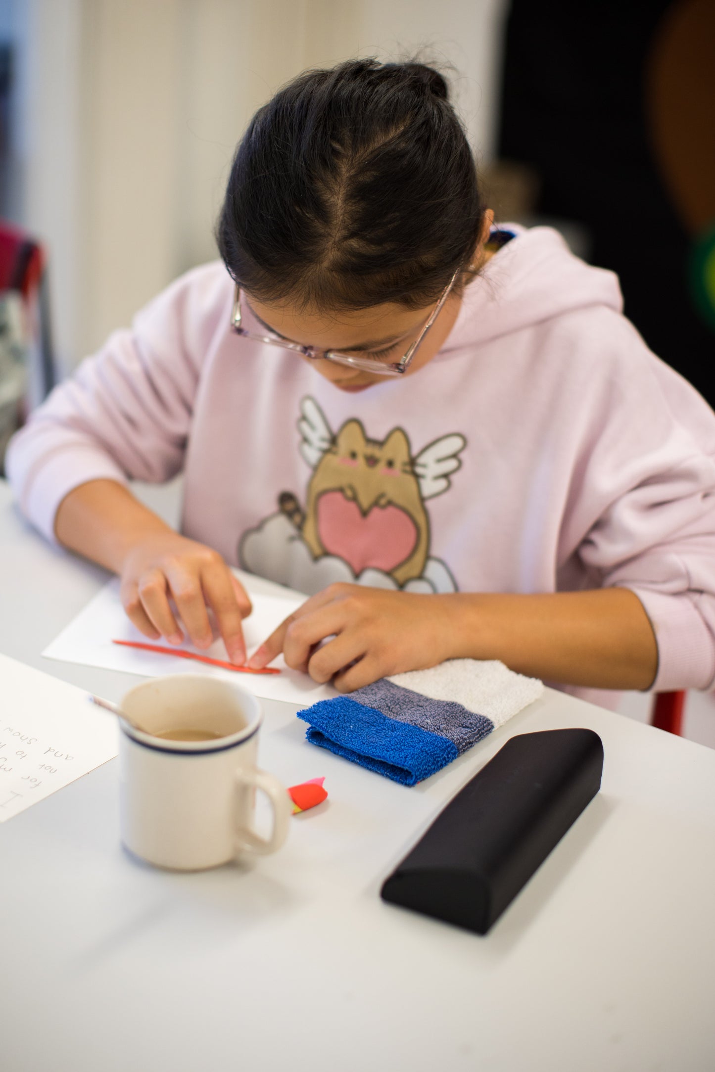 A 10-year-old participant deeply focused on shaping her non-dry clay creation at Emy's Mindful Clay Art Workshop, fully immersed in the creative process.