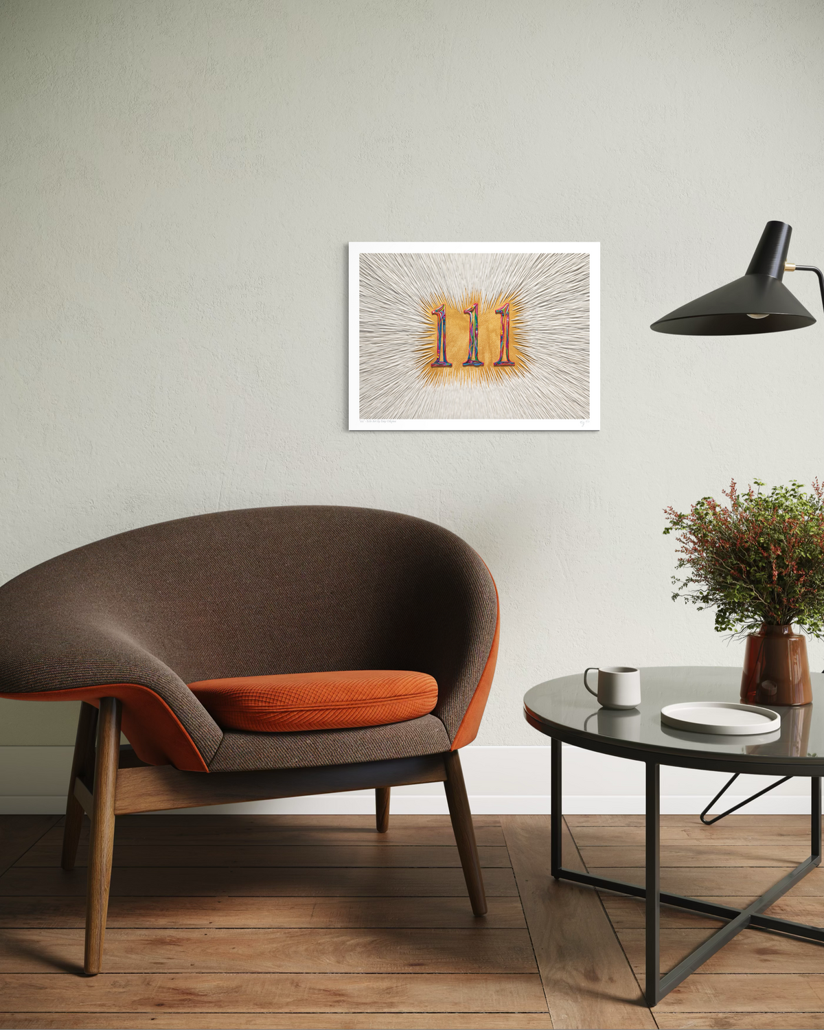 An A3 wall art print called ''111'' featuring the colourful plasticine angel number in gold background with a radial white line pattern, displayed in a modern living room setting above a brown armchair and next to a round coffee table.