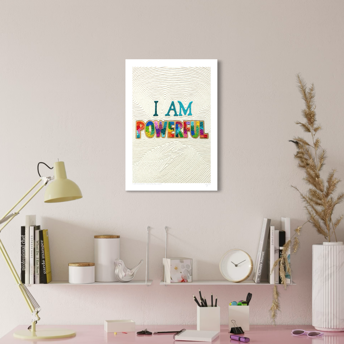 An A3 wall art print with the text 'I AM POWERFUL' hangs on a beige wall above a styled desk. Art by New Zealand clay artist Emy Oikawa from Eclo Art.