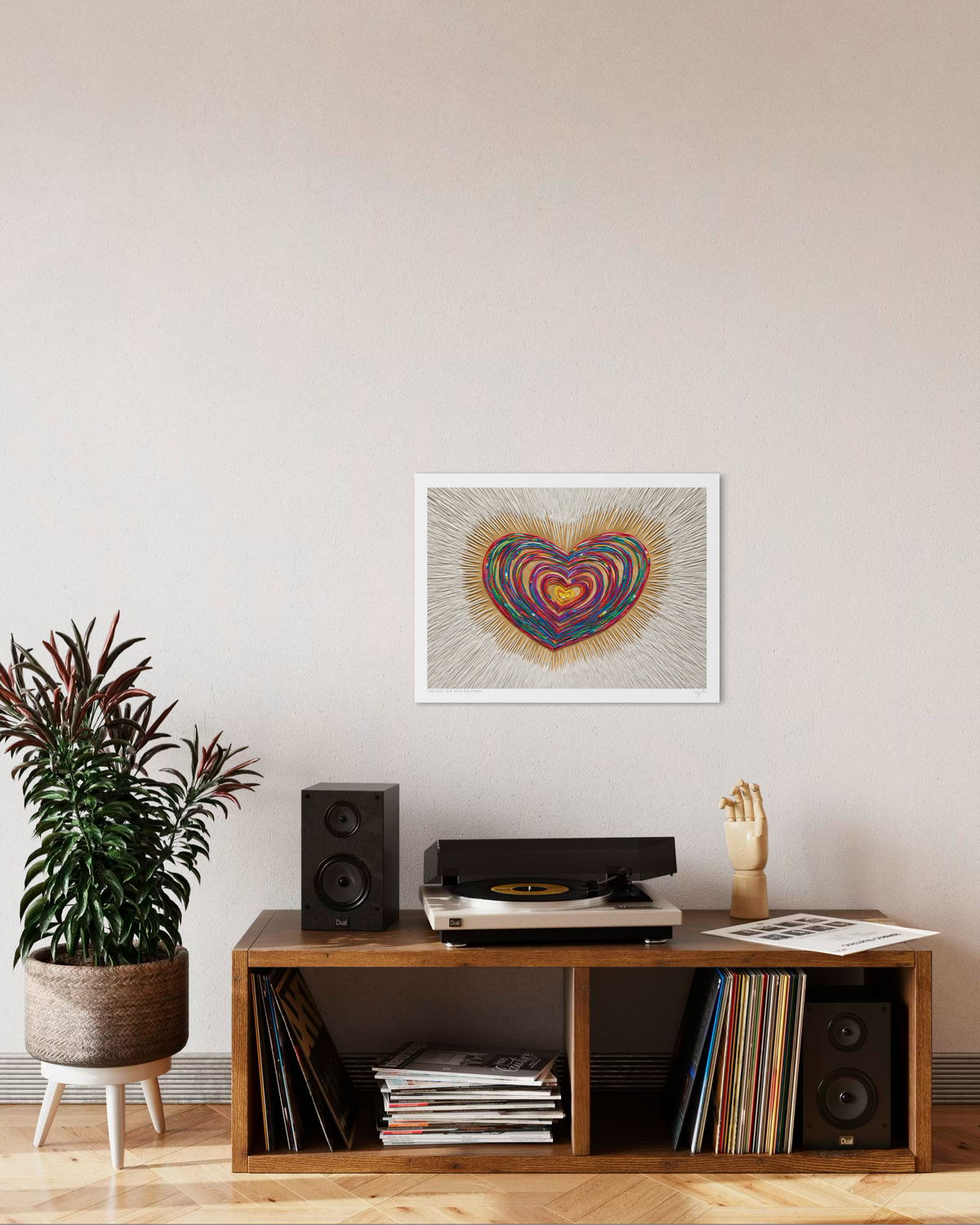 An A3 art print featuring a colorful, swirling heart piece called ''Only Love'', originally made with plasticine, hanging on a beige wall above a wooden media console with a record player, speakers, and books. Made by New Zealand Artist Emy Oikawa.