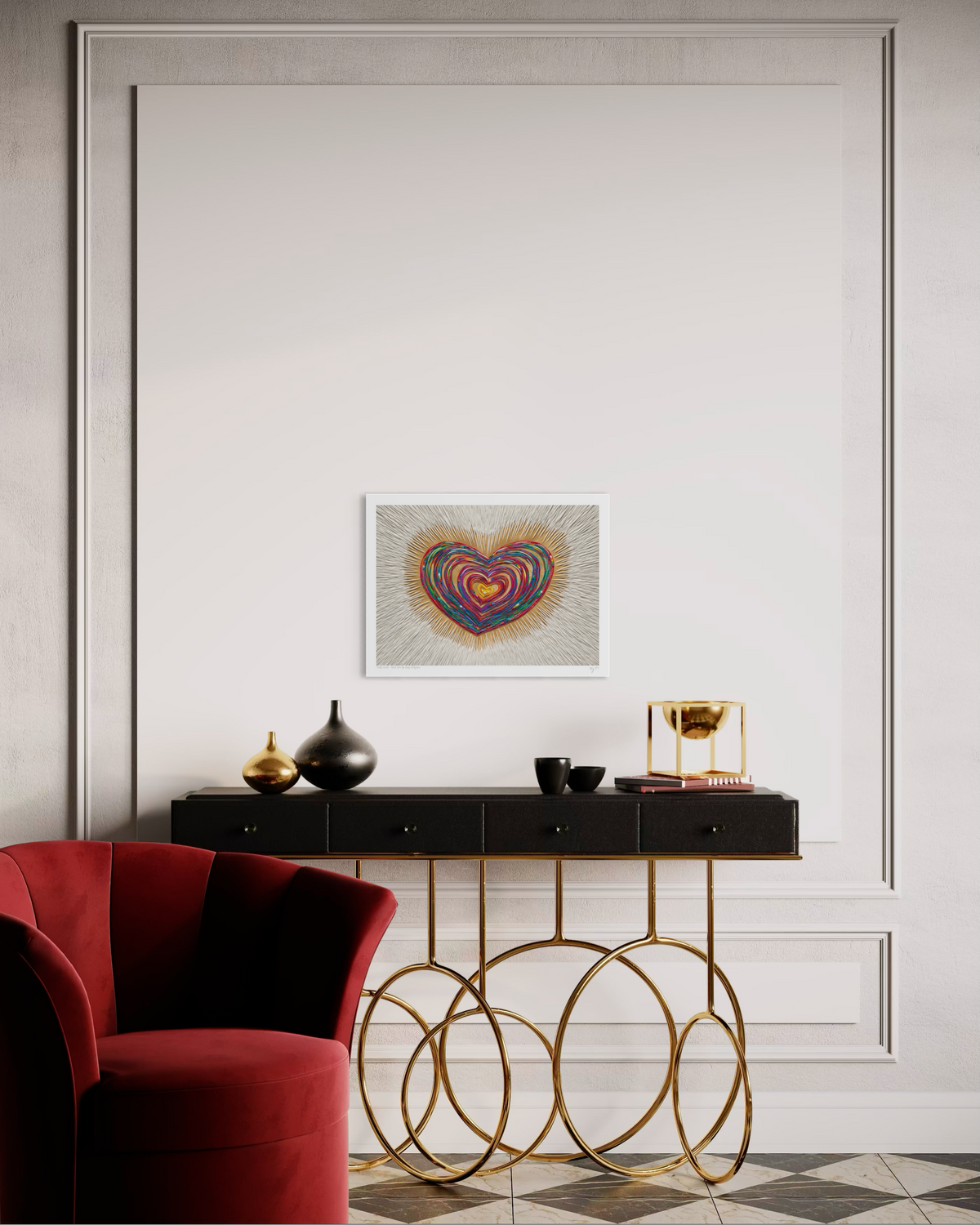 An A3 art print featuring a colorful, swirling heart piece called ''Only Love'' hanging on a white paneled wall above a black console table with gold metal legs. A red velvet armchair is visible in the foreground on a checkered floor.