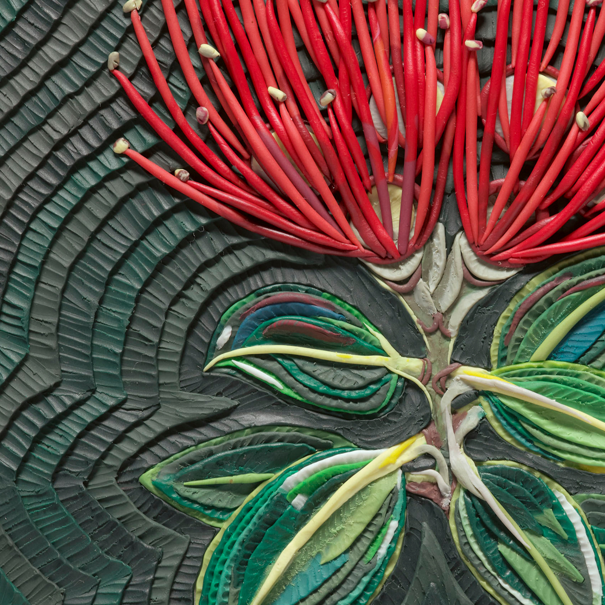 Close-up of a textured plasticine floral artwork featuring bright red New Zealand Pohutukawa flower radiating from a central stem with layered green and yellow leaves on a dark background. Art by clay artist Emy Oikawa from Eclo Art.