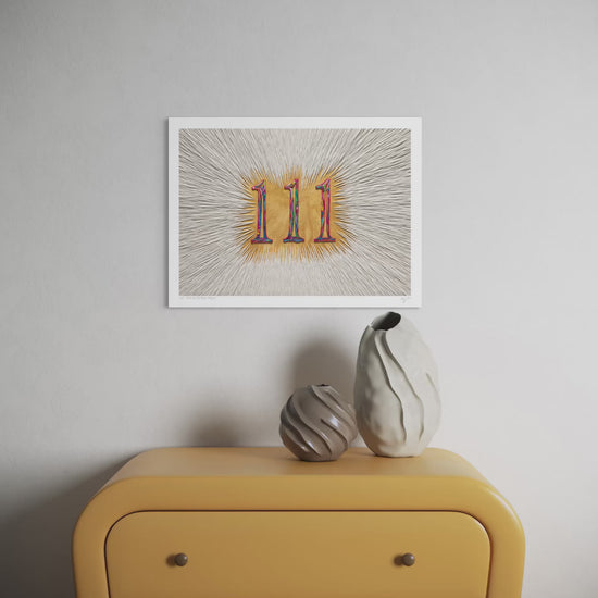 Close up video of an A3 art print featuring the number 111 (angel number) in a colorful gradient made with plasticine over a golden background, displayed on a light gray wall above a mustard yellow cabinet with two decorative vases. Art by Emy Oikawa from Eclo Art.